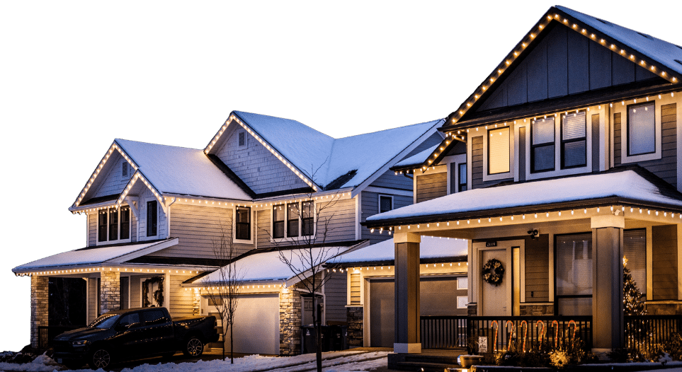 Three suburban homes are adorned with Christmas lighting, snow dusting the roofs, in a Portland, OR neighborhood. Warm white lights line the eaves, highlighting the architecture.
